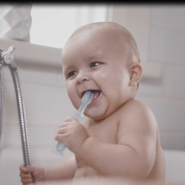 Bebé jugando con el cepillo/mordedor de Haakaa fomentando relación amable con la higiene bucal