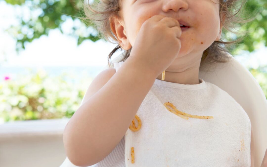 Niño empezando la alimentación complemetaría comiendo espaguetis solo